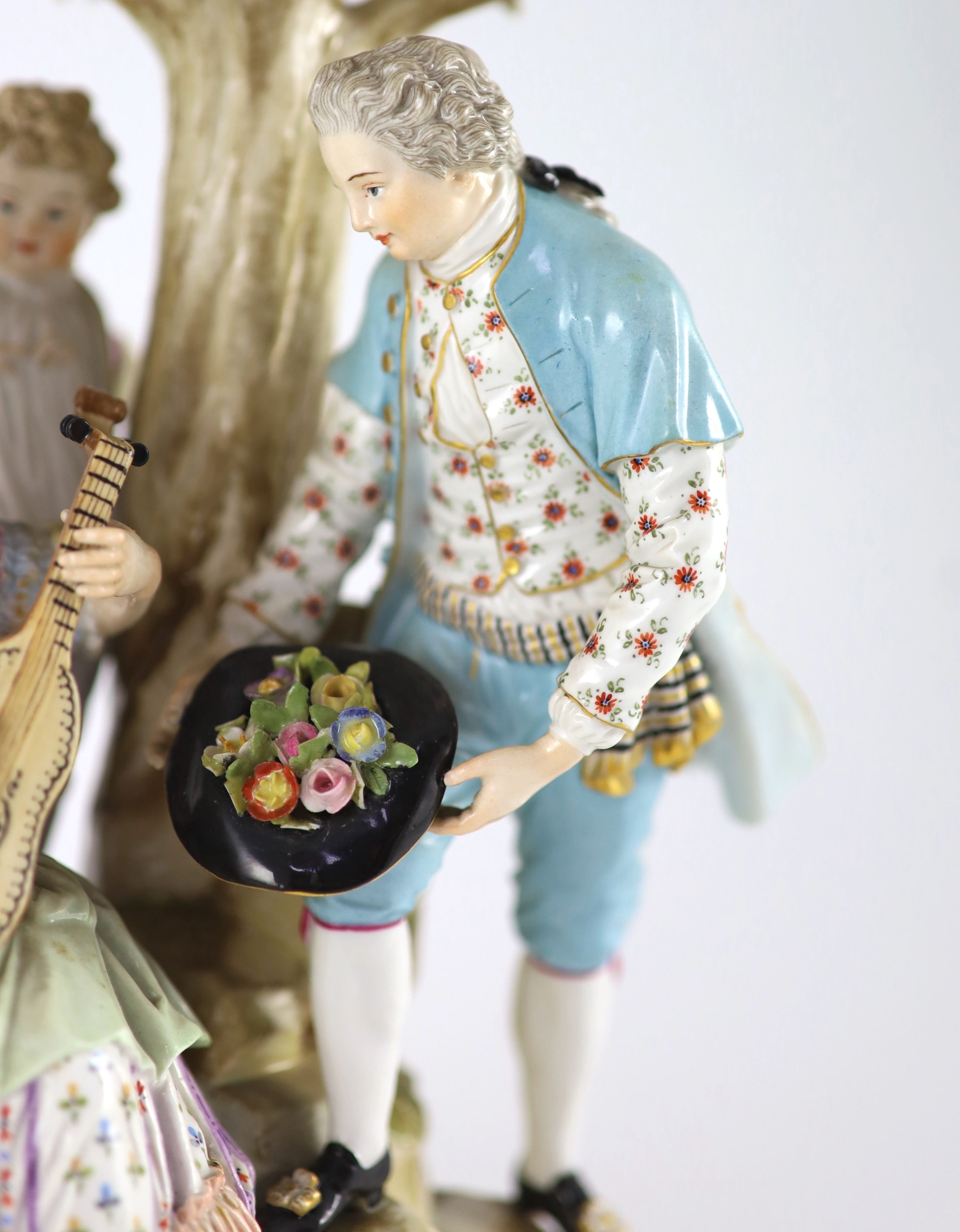 A Meissen group of flower pickers, 19th century, 26 cm high, losses to tree